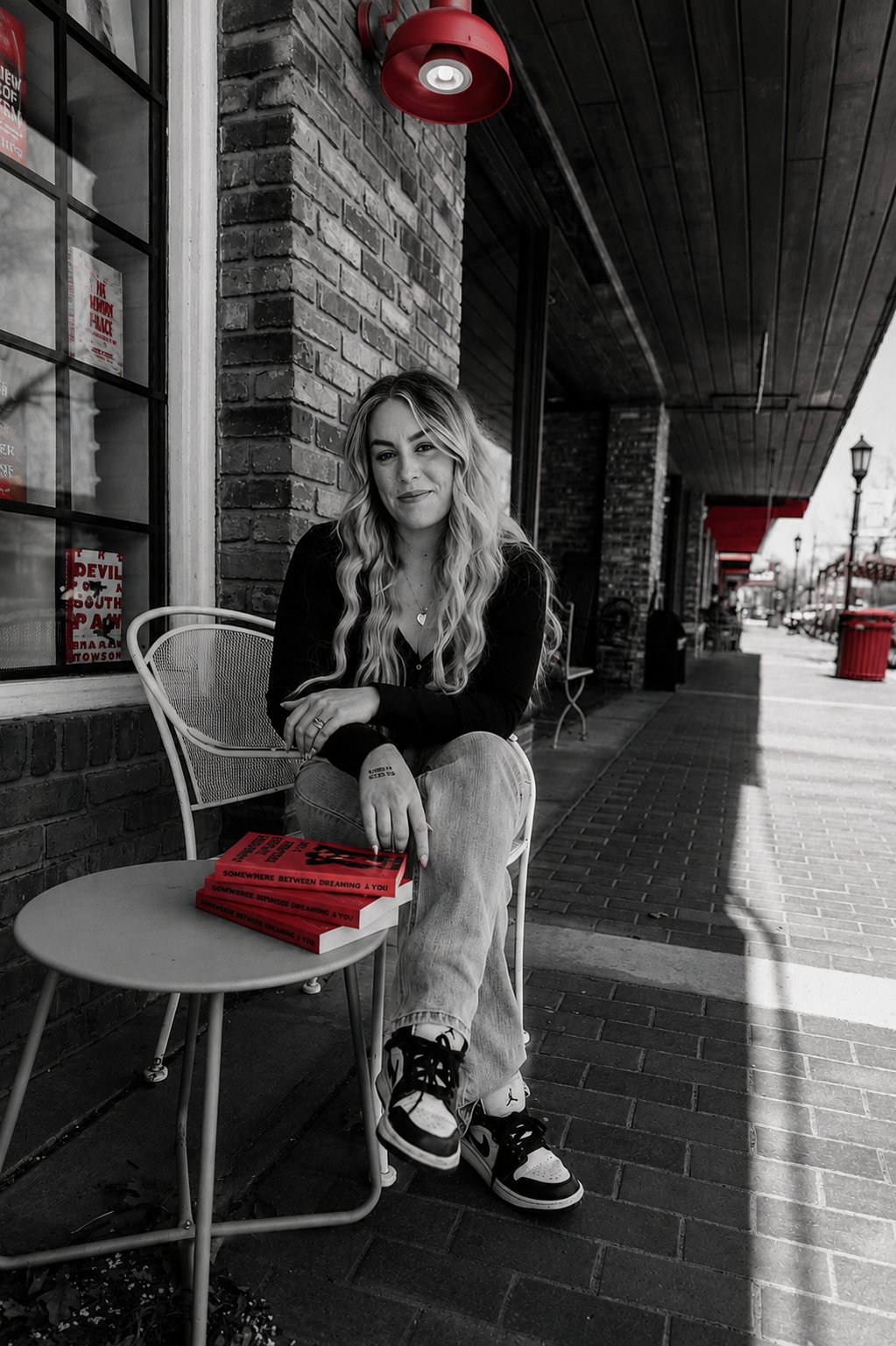 Kailey Brown at a café table with her novel